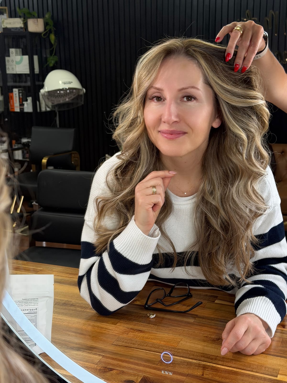 Cliente sorrindo com loiro mel iluminado e ondas