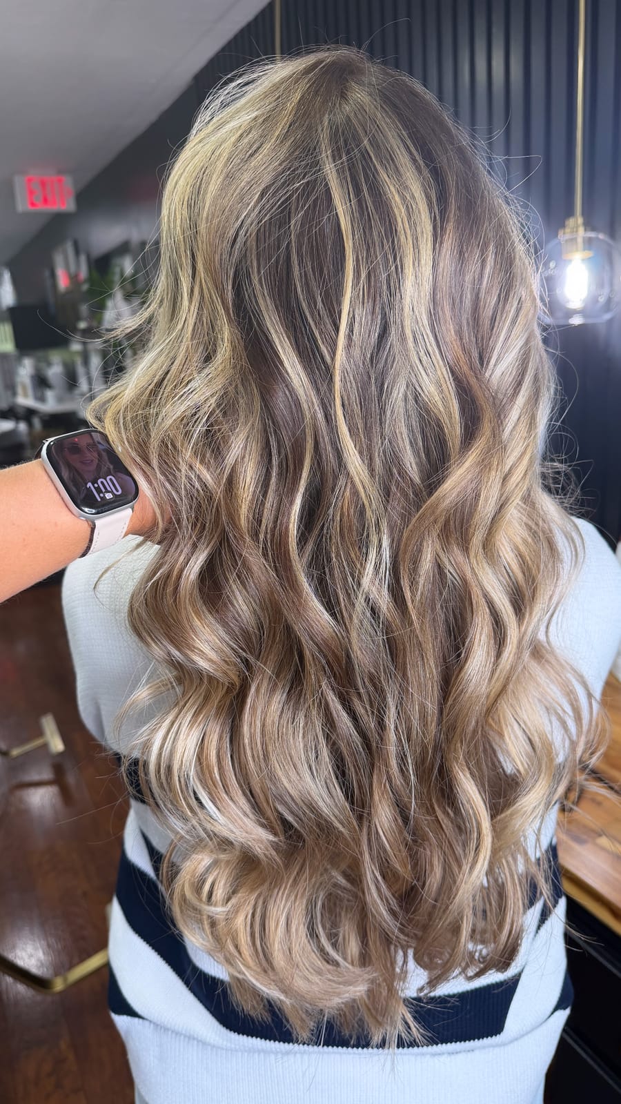 Cabelo loiro iluminado com ondas longas, visto de costas